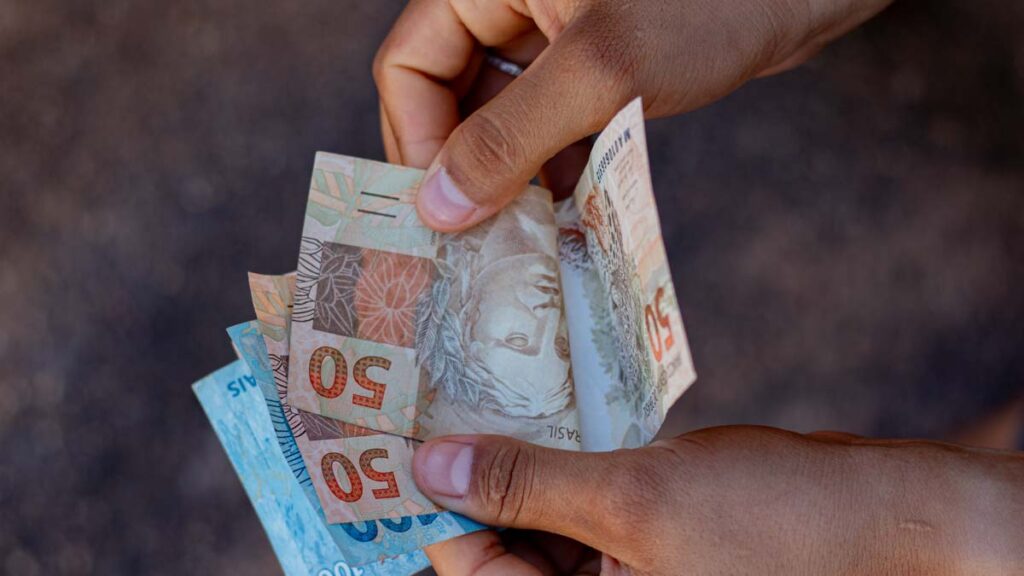 dinheiro-maos-7-1024x576 Confira a Nova Lista de CPF’s Liberados pela Caixa para Saques de Até R$ 1.412